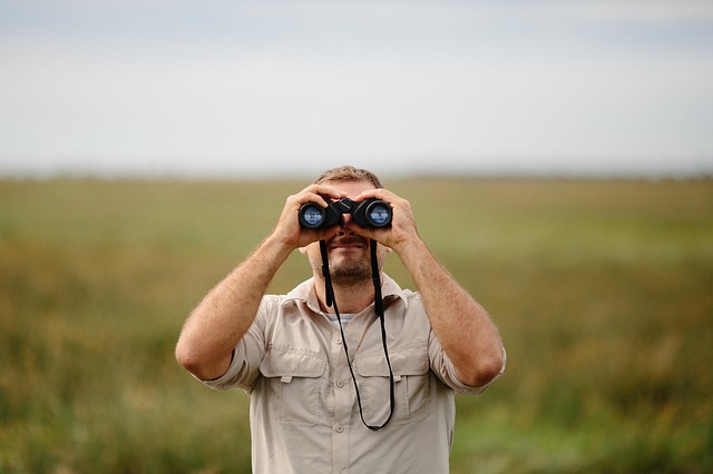 man with binoculars looking at you